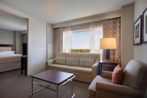 a hotel room with a couch and a bed at Sheraton Suites Fort Lauderdale Plantation in Plantation