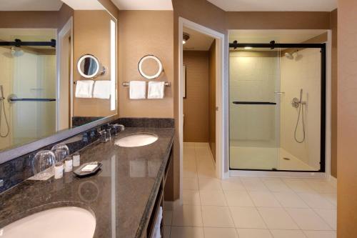 a bathroom with two sinks and a shower at Sheraton Suites Fort Lauderdale Plantation in Plantation