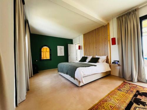 - une chambre avec un lit et un mur vert dans l'établissement Maison Luxueuse à Essaouira, à Essaouira