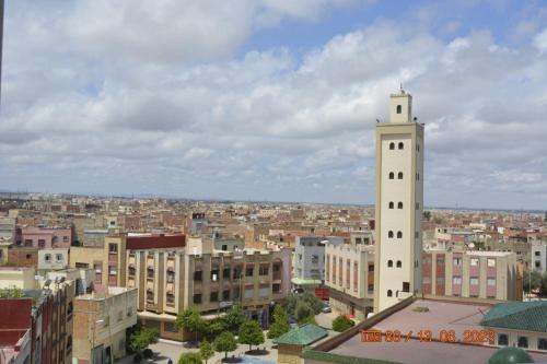 - une vue sur une ville dotée d'une grande tour blanche dans l'établissement FEKRI HOTEL, à Meknès