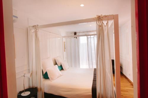 ein Schlafzimmer mit einem Himmelbett und einem Fenster in der Unterkunft Le Cocooning 974 Hôtel Restaurant Réunion in Antananarivo