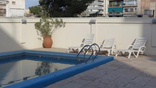 a group of chairs sitting next to a swimming pool at PREMIUM MENDOZA in Mendoza