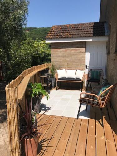 a wooden deck with a chair and a couch at Seawinds in Ventnor