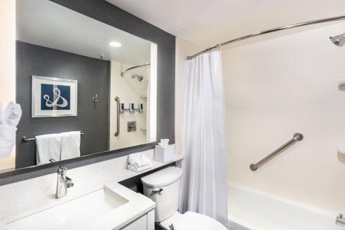 a bathroom with a toilet and a sink and a mirror at Four Points by Sheraton Los Angeles Westside in Los Angeles