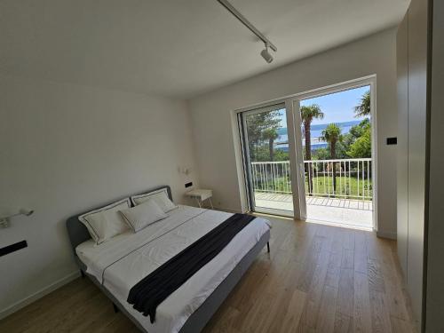 een slaapkamer met een groot bed en een groot raam bij Romantic New Superior apartments close to Sandy and pebble beach in Crikvenica
