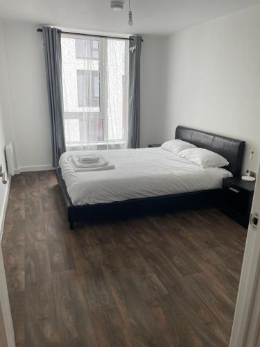 1 dormitorio con 1 cama y suelo de madera en Defining Luxury, Comfort& Class2 en Barking