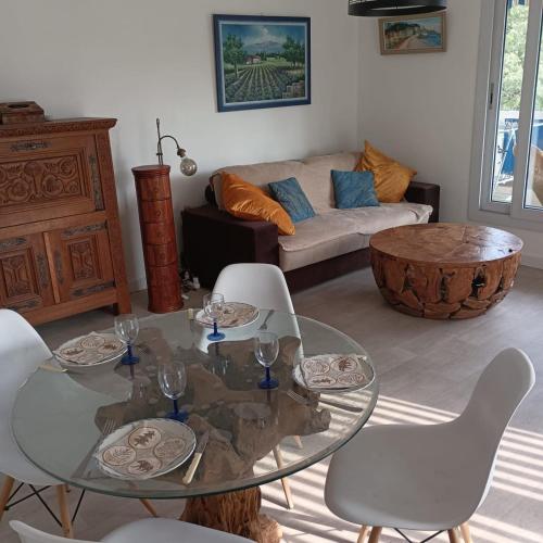 - un salon avec une table en verre et des chaises blanches dans l'établissement Apartment near the center of Vallauris, à Vallauris