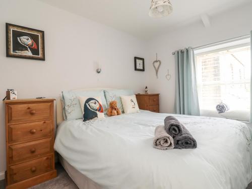 ein Schlafzimmer mit einem weißen Bett mit zwei ausgestopften Tieren in der Unterkunft Aln Cottage Alnwick in Alnwick