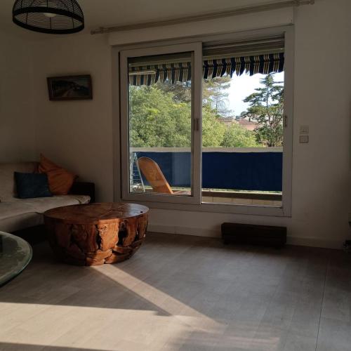 - un salon avec une table basse en stuc d'arbre devant une fenêtre dans l'établissement Apartment near the center of Vallauris, à Vallauris