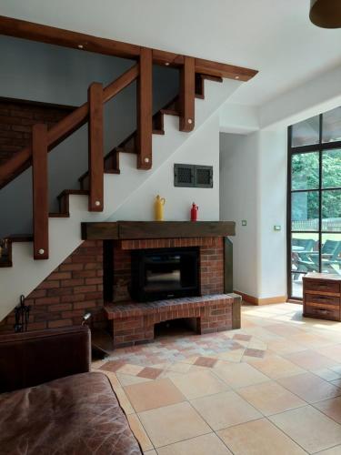 - un salon avec une cheminée en briques et des escaliers dans l'établissement CASA DIN PADURE, à Brad