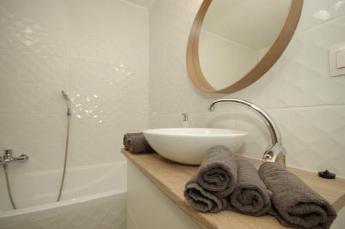 a bathroom with a sink and a mirror and a tub at Gyulai idill apartman in Gyula