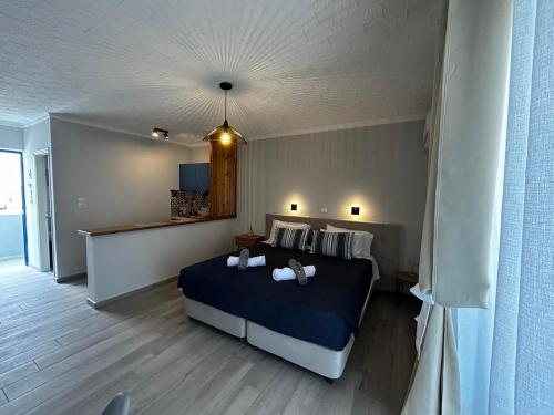 - une chambre avec un lit bleu et des serviettes dans l'établissement Mina Studios, à Kardamaina