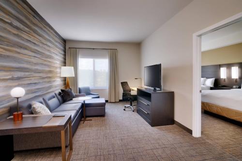 Residence Inn by Marriott Brunswick في برونزويك: غرفة في الفندق مع أريكة وسرير