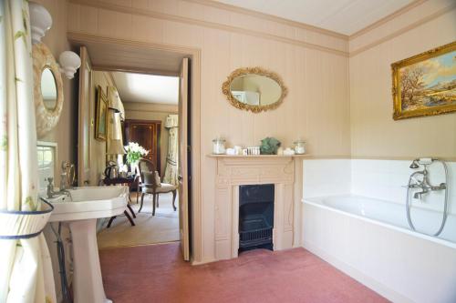 a bathroom with a tub and a sink and a fireplace at Wydemeet Bed and Breakfast in Two Bridges
