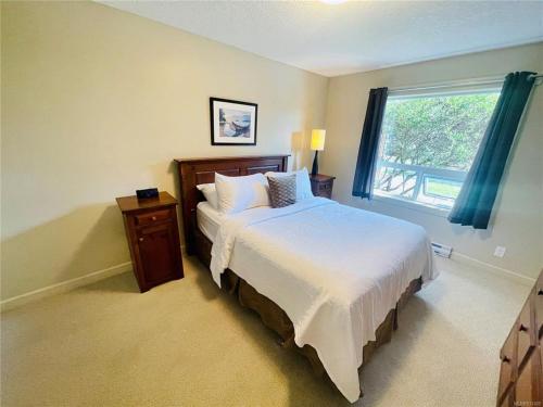 - une chambre avec un grand lit et une fenêtre dans l'établissement Ocean View Townhome - Sooke Harbour Marina, à Sooke