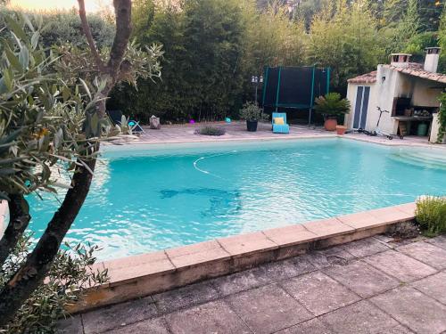 una grande piscina con acqua blu in un cortile di Chambre d hôte Entre Cigale et Pagnol a Peypin