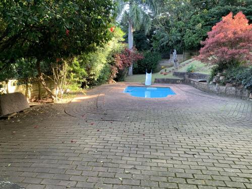 a brick driveway with a small pool in the middle of it at Maisha@Toti in Amanzimtoti