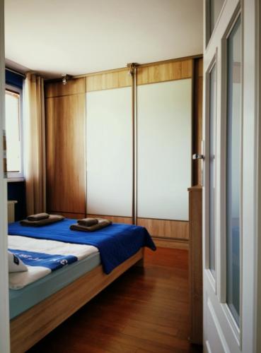 a bedroom with a bed with blue sheets at Apartament Morski z ogródkiem in Rumia