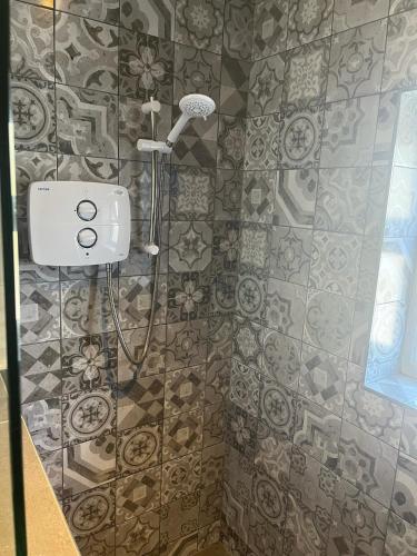 a shower with a shower head in a bathroom at Wellington Cottage in Wexford