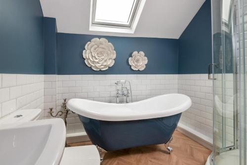 a blue and white bathroom with a claw foot tub at Beautiful 2-Bed Cottage in Brampton in Brampton