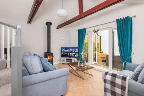 a living room with blue chairs and a fireplace at Cottage - Sleeps 3 hot tub & pet friendly in Brampton