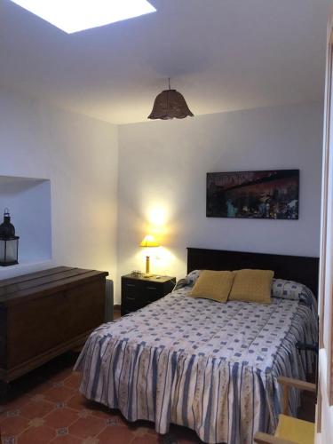 a bedroom with a bed and a table and a lamp at Cortijo Jayon in Fernán Pérez