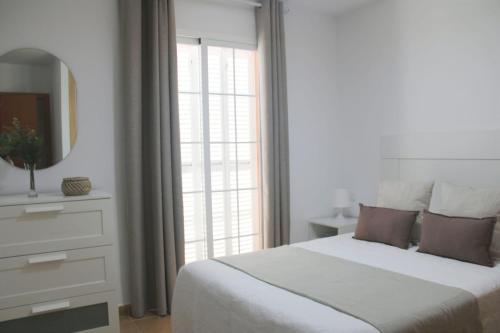 a white bedroom with a large bed and a mirror at Brisa Mar in Málaga