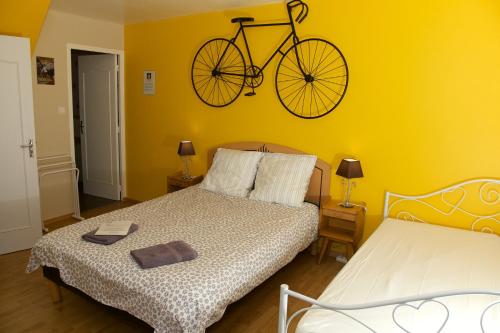 sypialnia z łóżkiem i rowerem na ścianie w obiekcie La Petite Chesnee w mieście Sacey
