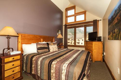 a bedroom with a bed and a tv and a window at Springs by Summit County Mountain Retreats in Keystone
