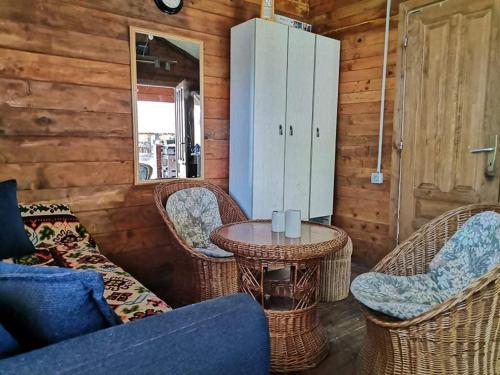 sala de estar con mesa y sillas de mimbre en EXIT Camping with bungalow, mobile home, tents, and empty spots with private acces to the beach en Novi Sad