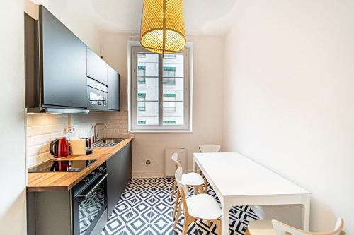 eine kleine Küche mit einer Theke und einem Tisch in der Unterkunft Le Bon Pasteur-cosy 2 pers- Croix Rousse in Lyon