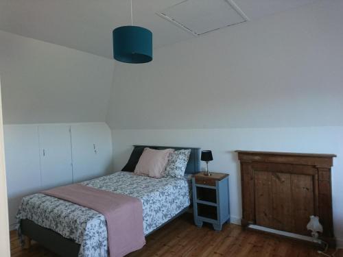 a small bedroom with a bed and a night stand at Ti Mammig Reina in Guissény