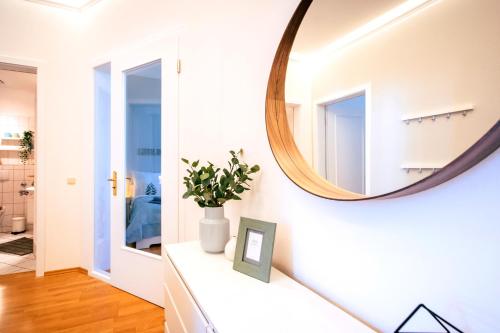 ein Spiegel an einer Wand neben einem Flur in der Unterkunft Gemütliche Ferienwohnung neben der Arena Leipzig "Waldi" in Leipzig