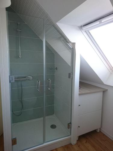 a bathroom with a glass shower in a attic at Ti Mammig Reina in Guissény