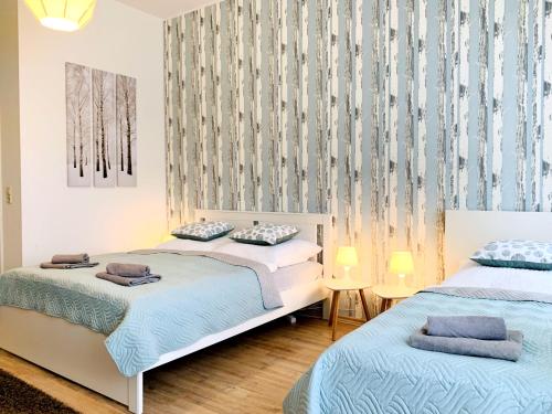 um quarto com 2 camas e uma parede com cortinas em Zentrumsnahe Ferienwohnung mit ruhigem Balkon - "Arthur" em Leipzig