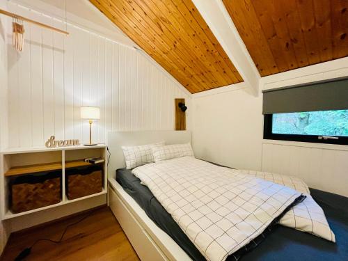 een bed in een kleine kamer met een tv bij Ferienhaus Kleine Auszeit in der Natur mit Kamin, Yogamatten, schöne Küche in Extertal