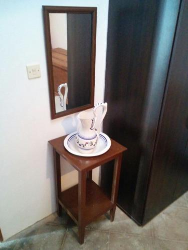 a small table with a mirror and a vase on it at Cortijo Jayon in Fernán Pérez