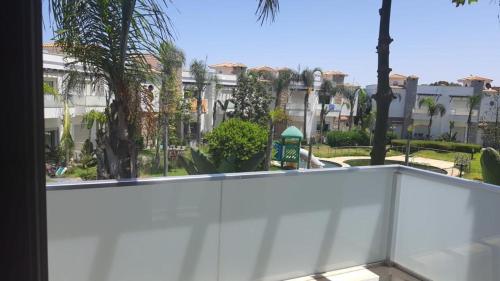 a view from the balcony of a building with palm trees at BEAU TRIPLEX EN RESIDENCE in Skhirat