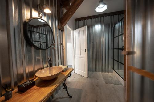 W łazience znajduje się drewniana umywalka i lustro. w obiekcie Miły Młyn w mieście Lubrza