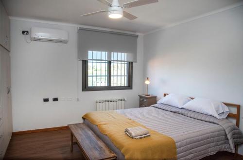 a white bedroom with a large bed and a window at Finca Mosso Lunlunta in Lunlunta