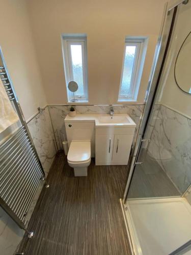 a bathroom with a toilet and a sink and a shower at Storey Apartment - 2 Bedroom upstairs flat in Newbiggin-by-the-Sea