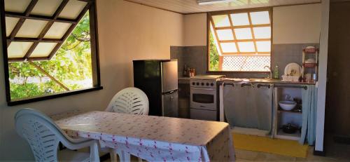 eine Küche mit einem Tisch, einem Tisch und Stühlen in der Unterkunft FAKARAVA - Teariki Lodge 2 in Fakarava