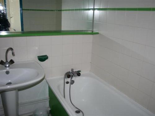ein Badezimmer mit einem Waschbecken, einer Badewanne und einem Spiegel in der Unterkunft Studio Port Barcarès, 2 pièces, 4 personnes - FR-1-195-25 in Le Barcarès