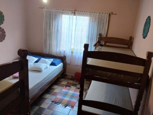 um quarto com 2 beliches e uma janela em Hostel Familiar Artesanal em Ubatuba