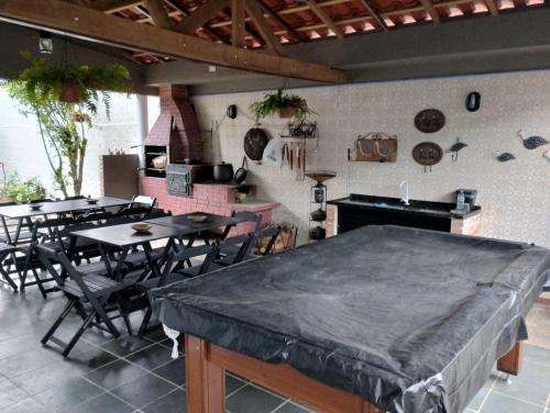 uma sala de jantar com mesas e cadeiras e uma cozinha em Hostel Familiar Artesanal em Ubatuba