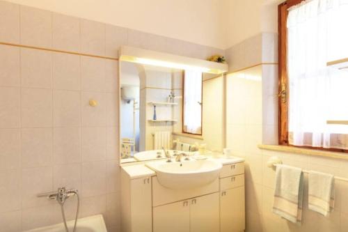 a white bathroom with a sink and a mirror at Villa Due Laghi in San Feliciano