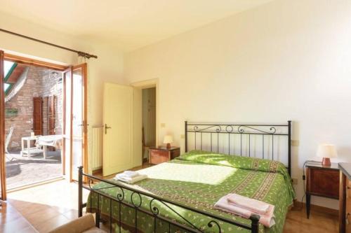 a bedroom with a bed with a green bedspread at Villa Due Laghi in San Feliciano