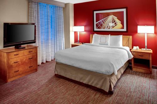 ein Hotelzimmer mit einem großen Bett und einem Flachbild-TV in der Unterkunft Residence Inn Atlanta Midtown 17th Street in Atlanta