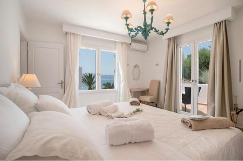 a white bedroom with a large bed with a window at Villa Sofia in Stelida