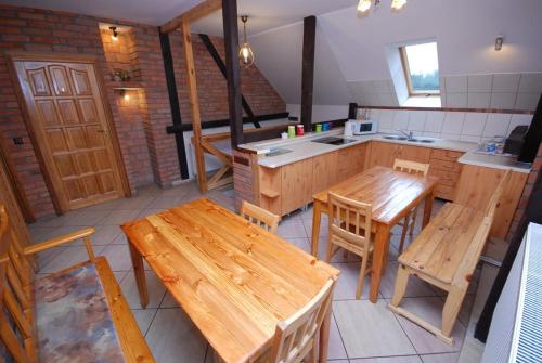 a kitchen with wooden tables and chairs and a counter at Noclegi Dorotowo in Dorotowo